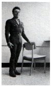 standing with hand on chair to brace oneself